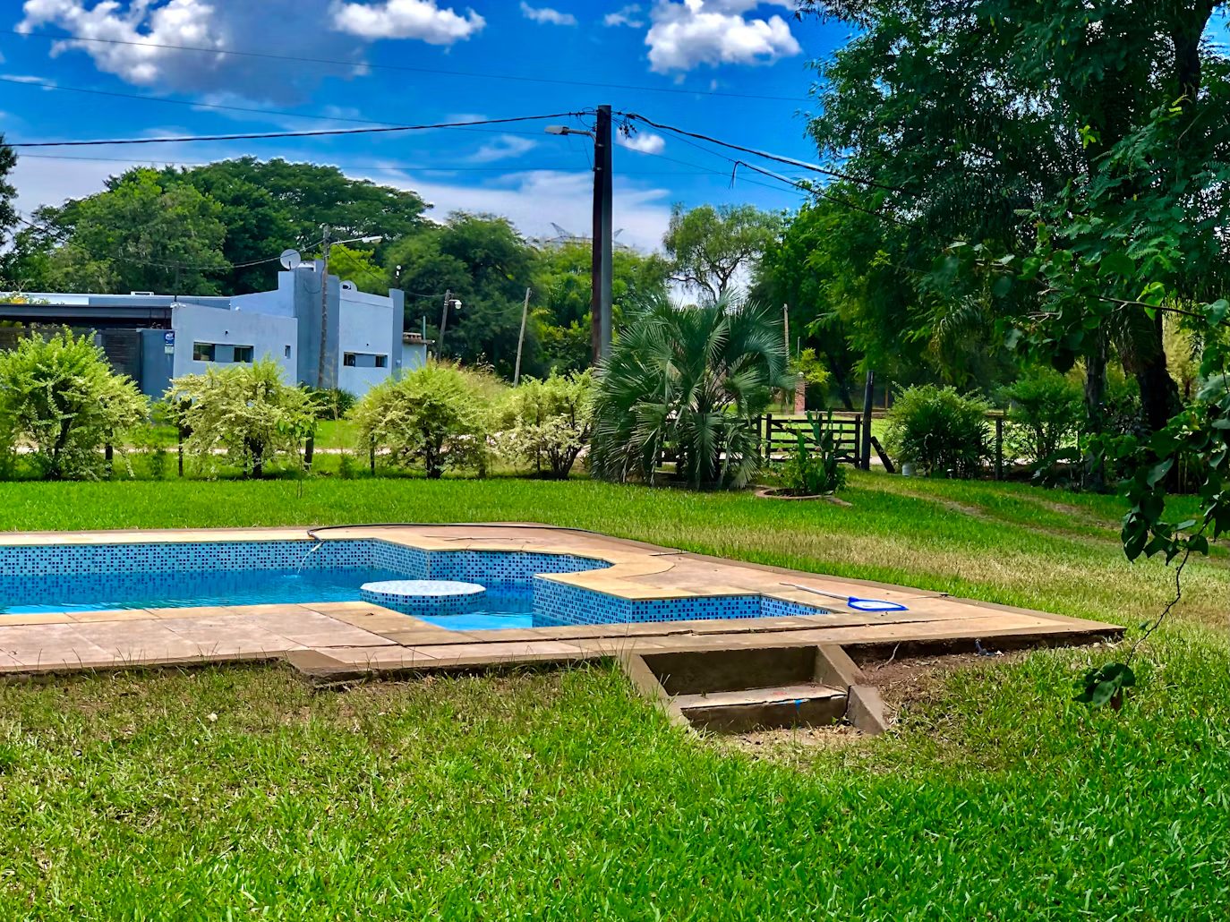 A tiled garden pool set into a green lawn