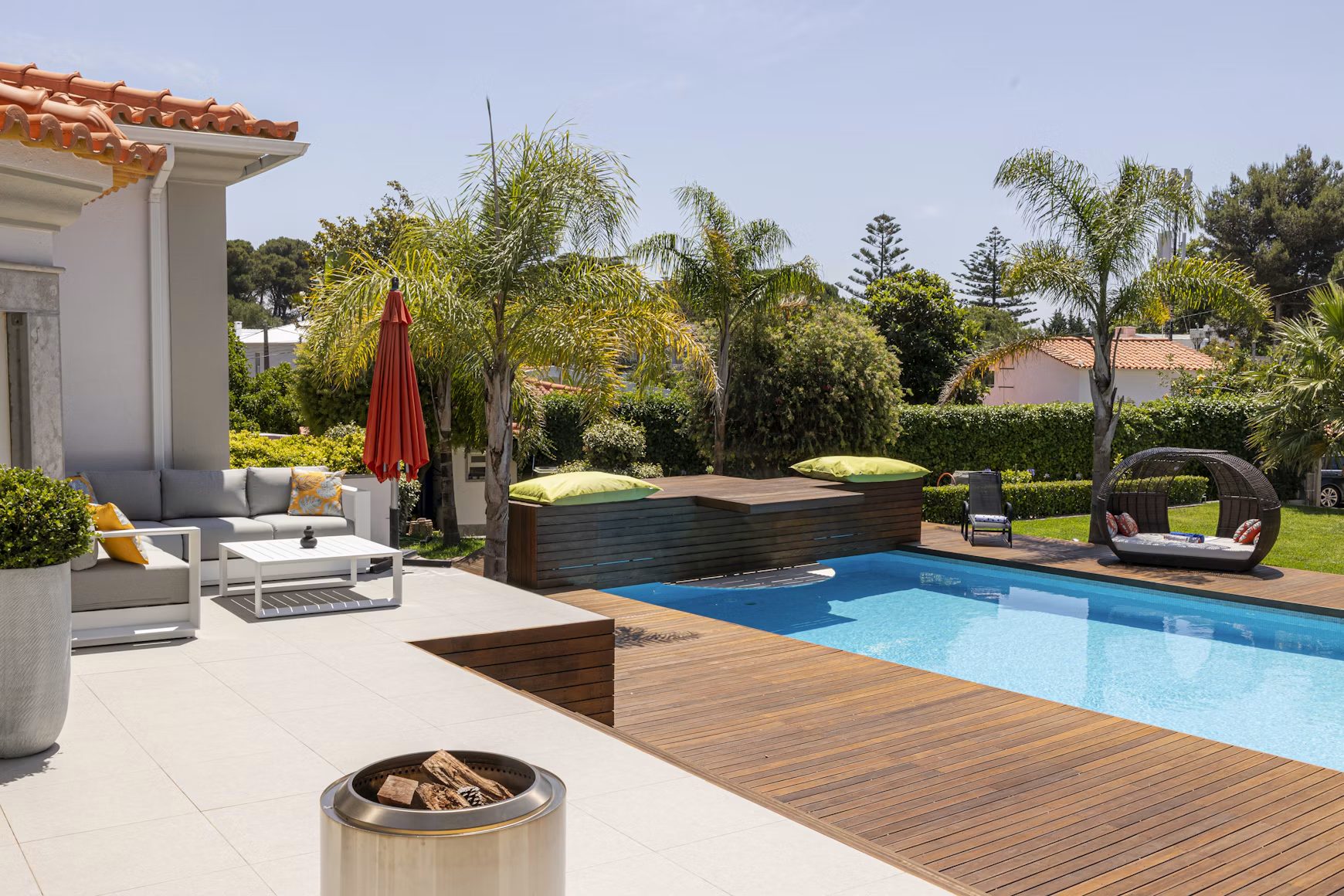 A pool terrace with a wooden deck, set and ready for guests